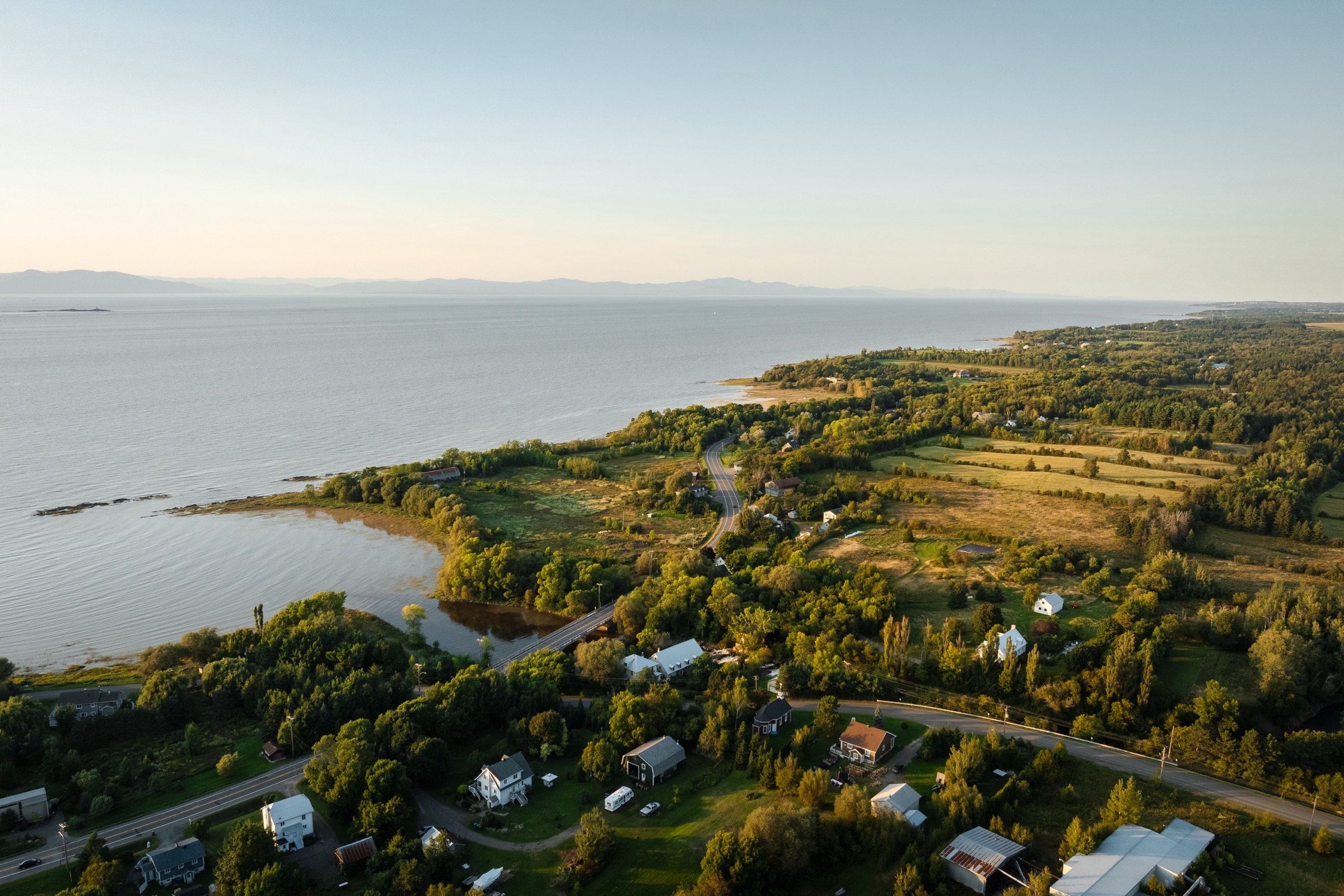 Vue aérienne de Saint-Jean-Port-Joli au soleil couchant — le fleuve Saint-Laurent, l'embouchure de la rivière Trois-Saumons et le village